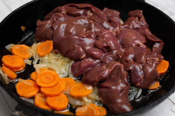Chicken liver, carrots, onions in a pan. Preparation of the pate. Recipe. Roasting ingredients.