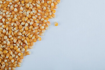 Heap of raw popcorn grains on white background