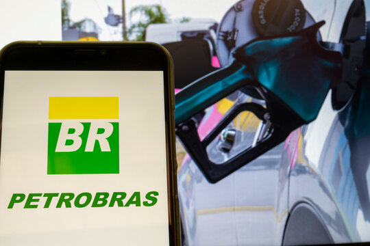 São Paulo, Brazil - February 23, 2021: cell phone with Petrobras logo, and in the background, blurred image of fuel supply in vehicle. Fuel prices.