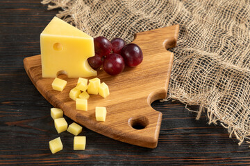 Cheese, grapes and nuts on a cutting board