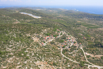 Fototapeta na wymiar Aerial drone view of Zena Glava village near Tito's Cave on Vis Island with view of adriatic coastline