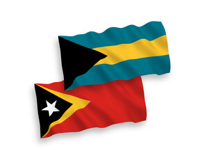 National vector fabric wave flags of East Timor and Commonwealth of The Bahamas isolated on white background. 1 to 2 proportion.