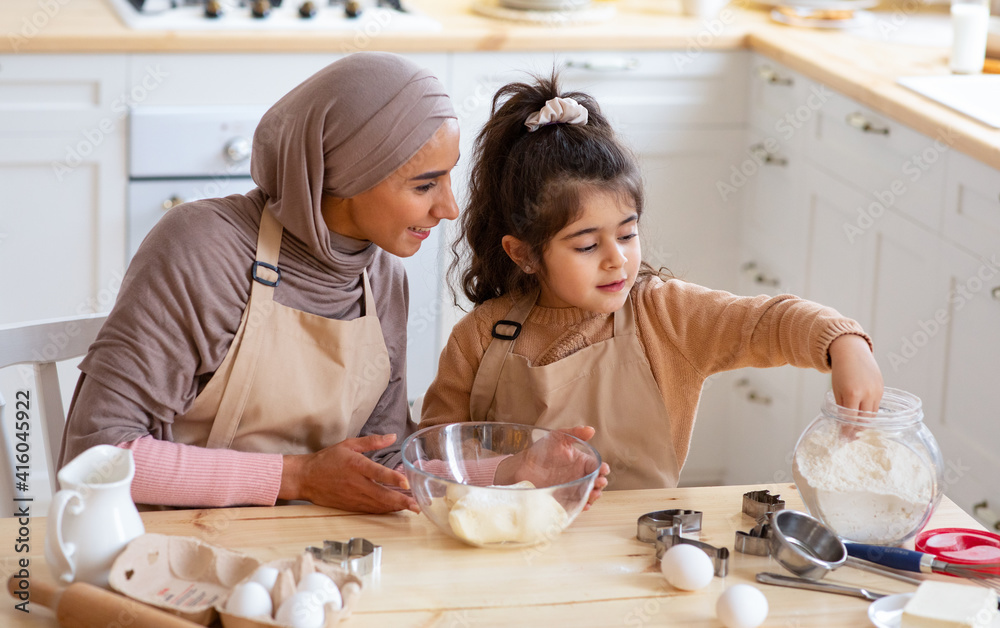 Poster Cute Little Girl And Muslim Mom In Hijab Preparing Pastry In Kitchen