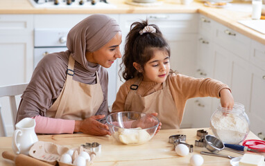 Cute Little Girl And Muslim Mom In Hijab Preparing Pastry In Kitchen