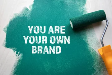 Fotobehang You Are Your Own Brand. Green painted wooden background © STOATPHOTO