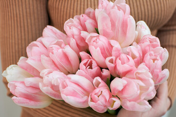 girl holding a beautiful bouquet of delicate tulips in her hands. flowers close up