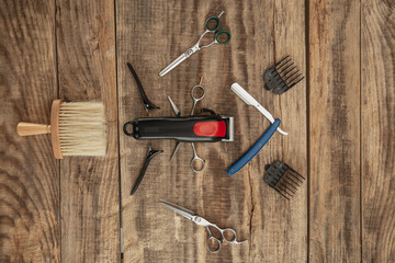 Barber shop equipment set isolated on wooden table background. Close up sccissors, comb, brushes, razors, professional tools of hairdresser. Professional occupation, art, self-care concept. Magazine.