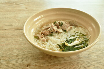 boiled vermicelli thin rice noodles topping slice braised pork in herb brown soup on bowl
