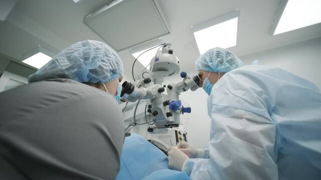 Surgery team making strabismus surgery using modern technologies, latest devices, microscope in modern clinic