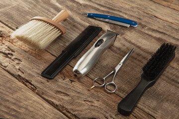 Barber shop equipment set isolated on wooden table background. Close up sccissors, comb, brushes, razors, professional tools of hairdresser. Professional occupation, art, self-care concept. Magazine.