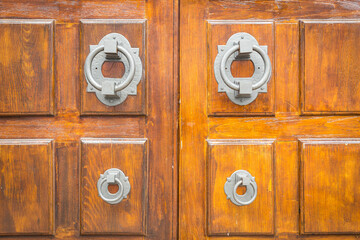 background of a brown wooden door with grey knockers