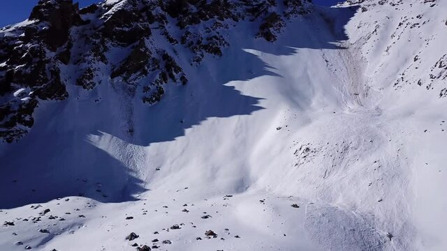 There was an avalanche in the mountains. Top view from the drone. Steep slopes and large rocks. A dangerous place. There were several avalanches. Snow-capped peaks of the Trans-Ili Alatau. Almaty