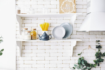 White kitchen wooden shelf with  blue teapot and accessories,  sugar bowl, grey plates and bowl...