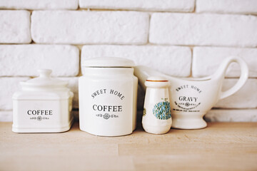 Close up of white salt shaker and coffee on wooden table. Containers with the words coffee