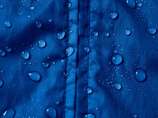 Water drops on waterproof membrane fabric. Detail view of texture of blue waterproof cloth.