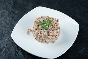 Delicious buckwheat with greens on a white plate