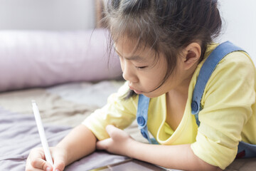 Naklejka premium Preschool girl using tablet computer relax in cozy room