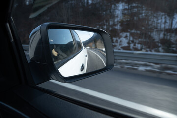 driving on the highway, looking at the exterior side mirror