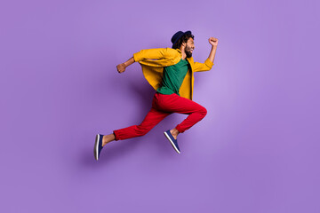Fototapeta na wymiar Full length photo of purposeful dark skin guy dressed yellow shirt headwear jumping running fast isolated purple color background