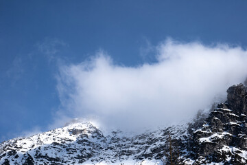 Fototapeta na wymiar cloud on top of the mountain. Italian Alps