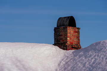Red glowing bricks of chimney of an abandoned house in winter.