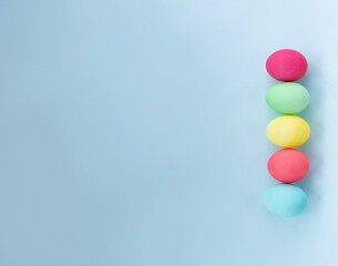 easter eggs dyed in pastel colors against light blue background. Image with copy space