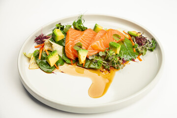Salmon and avocado salad in tamarind sauce on a plate. Ingredients Iceberg lettuce, salmon, avocado, spinach, carrot, tamarind sauce. For restaurant menu