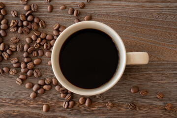 木目背景にコーヒー豆とコーヒーカップ