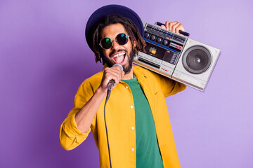 Photo of excited funky gut hold boom box mic singing enjoy free time isolated on magenta color background