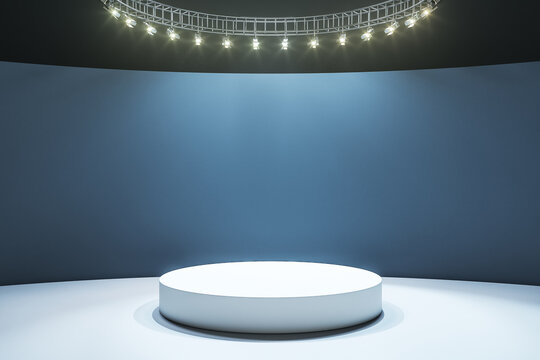White round podium on light floor in empty hall with dark wall and led lights © Who is Danny