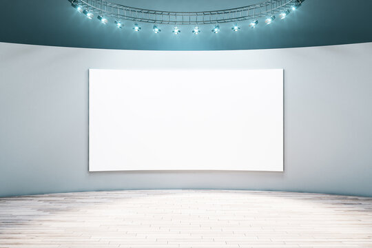 Spacious empty hall room with blank white poster on light wall, parquet floor and led light on top. Mockup © Who is Danny