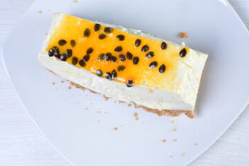 Yellow colorful passion fruit fluffy dessert on white wooden background