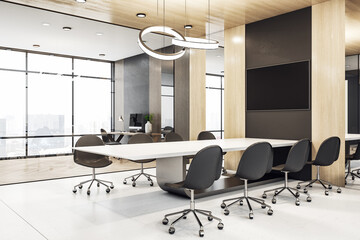 Blank black tv screen on brown wall in modern meeting room above light table, dark chairs and city view from big window