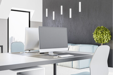 Blank grey computer monitor on modern table in light office with grey wall and city view. Mockup