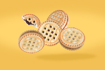 Baked flying cookies pastry sweet dessert.  Flying in air cookies isolated on pastel yellow background.