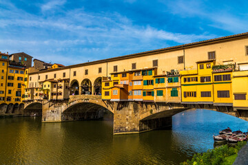 Fototapeta na wymiar Beautiful close-up view of the medieval bridge Ponte Vecchio over the Arno River in the historic centre of Florence. The bridge with three segmental arches is famous for the shops built along it.