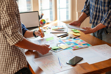 Team of web designers design mobile application layouts.