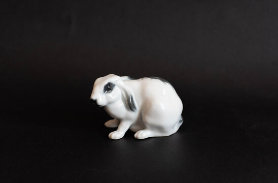 Vintage porcelain rabbit figurine on black background