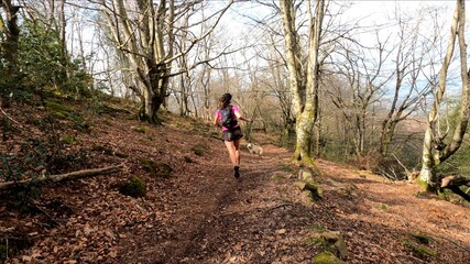 young woman trail running in the mountains