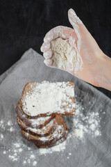 Female hand pouring a pinch of flour on bread