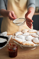 Vertical image of sprinkling and decorating cookies with powdered sugar