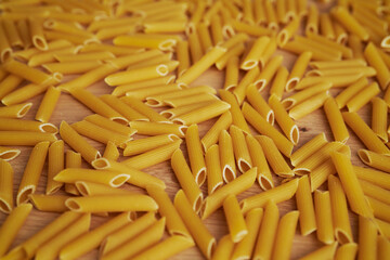 Detail of penne pasta scattered on the kitchen counter