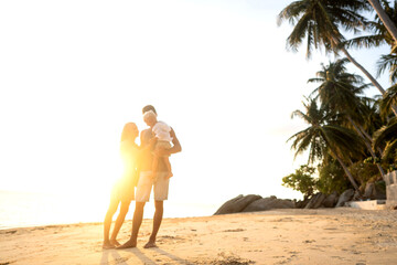 happy family walking on the beach at sunset