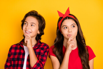 Photo of thoughtful girl boy hand on chin look interested empty space imagine isolated on yellow color background