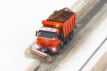 Snowplows removing the snow the highway on a cold snowy winter day.