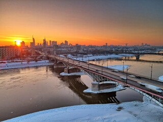 sunset view of the Vistula river and railway and road bridges and the sun setting over the center...