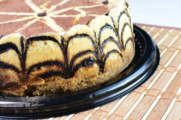 Cake decorated with vanilla and arequipe on white plate and light colored wooden background