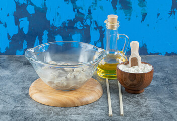 A glass plate with dumplings on a wooden board with oil and flour