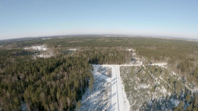 Epic winter aerial footage flying over snowy forest road on a cold sunny day, drone footage with GoPro hero 9 camera.