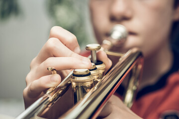 Close up of a child playing a trumpet  - obrazy, fototapety, plakaty